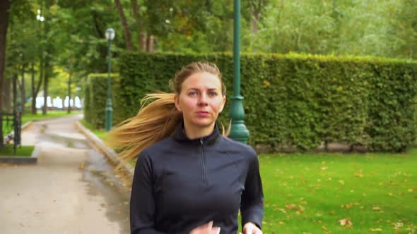 Young woman jogging in autumn park in the morning