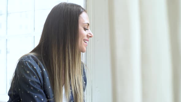 Woman looking outside through the window