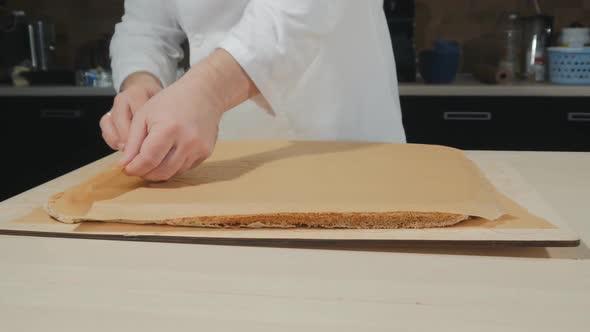 the Pastry Chef Removes the Baking Paper From the Biscuit That Has Just Been Baked. The Paper Is