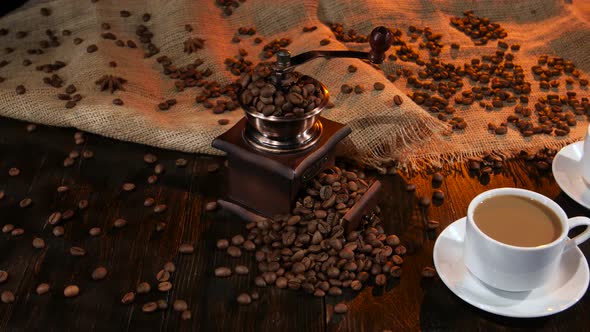 Two Cups with Latte on Table Strewn with Coffee Beans