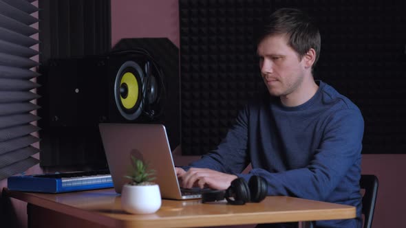 Sound Designer Working on Notebook in Music Studio