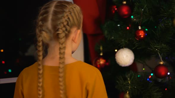 Lonely Girl Hanging Ball on Christmas Tree in Orphanage, Thinking About Family