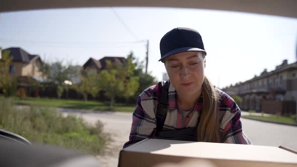 Delivery Courier Unloading Boxes From Car Trunk