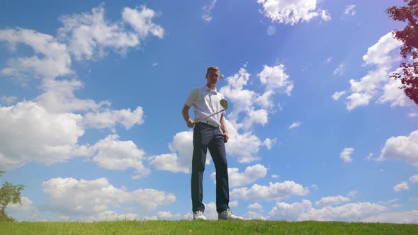 A Man Juggles Golf Ball with a Golf Club.