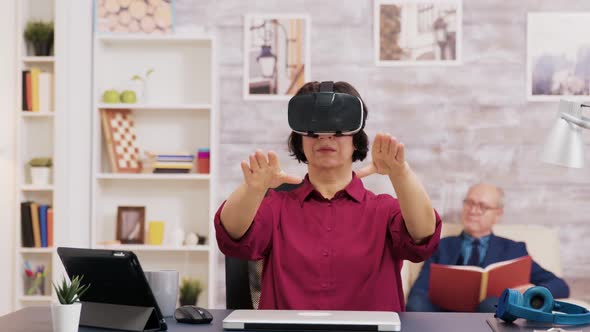 Retired Senior Woman Amazed While Using Virtual Reality Goggles