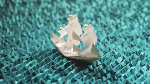 Tiny little paper ship sailing on an artificial cyan sea in looping animation 4K