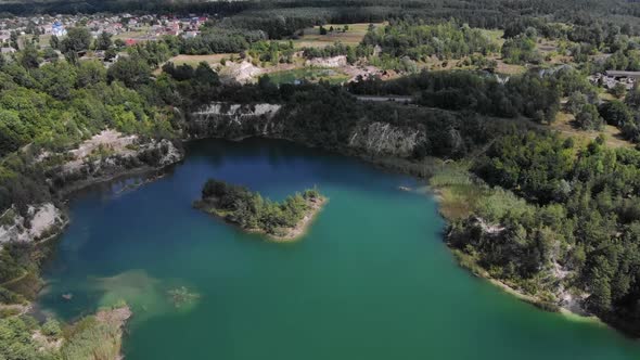 Aerial View of Beautiful Lake With Small Island and Blue Water Enclosed by Rocky Cliffs