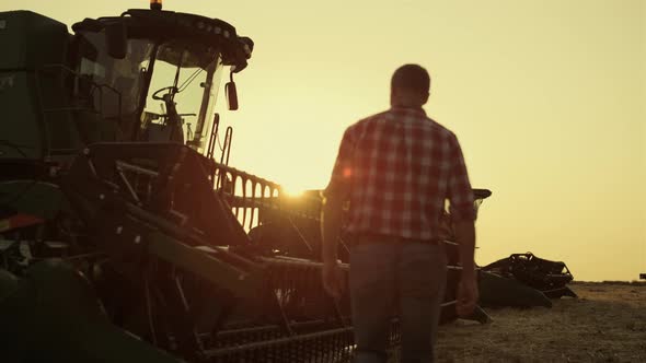 Farmer Checking Combine Working on Rye Golden Countryside Field Producing Wheat