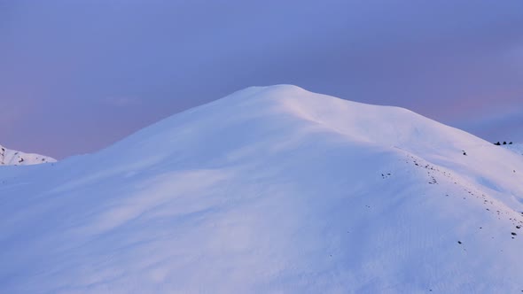 Aerial View of a Winter Mountain Ridge Before Sunrise or After Sunset. Snow Covered Top of Mountain