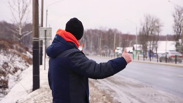 A Travel Man Catches a Passing Vehicle Raises His Hand