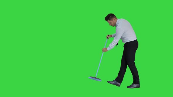 Man in Official Clother Sweeping the Floor on a Green Screen, Chroma Key