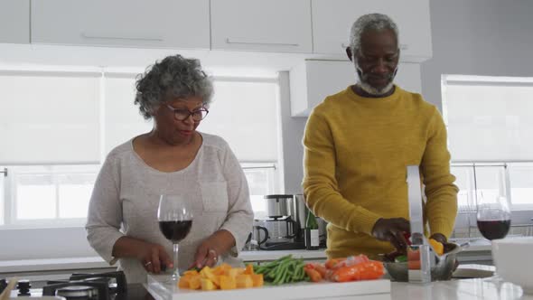 A senior african american couple spending time together at home and cooking social distancing in qua