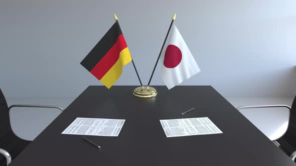 Flags of Germany and Japan and Papers on the Table alt