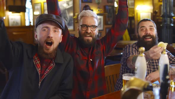 Cheerful Friends Having Fun Watching Football Game on Tv and Drinking Draft Beer at Bar Counter in