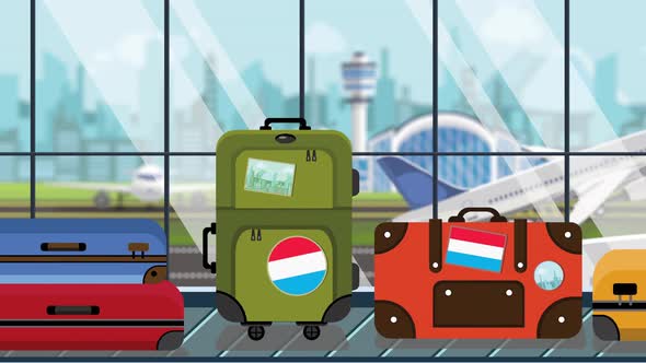 Suitcases with Flag of Luxembourg Stickers on Carousel in Airport