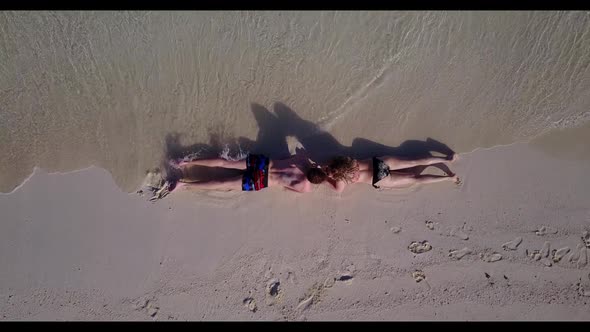 Guy and girl engaged on paradise resort beach trip by blue lagoon with white sandy background of the