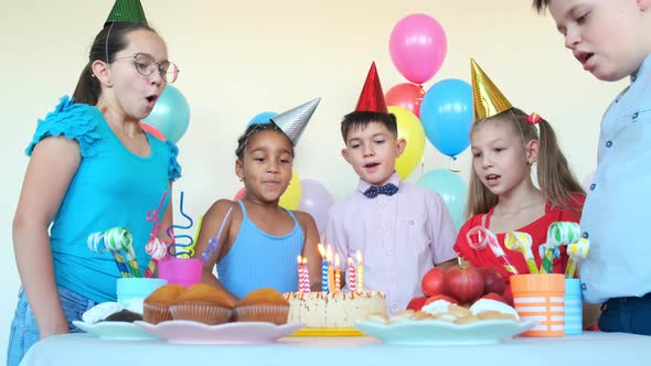 Friends Blow Candles on Cake Celebrating Birthday at Table