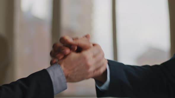 Close Up Male Arms of Two Multiethnic Unrecognizable Business Men in Suit People Funny Handshaking