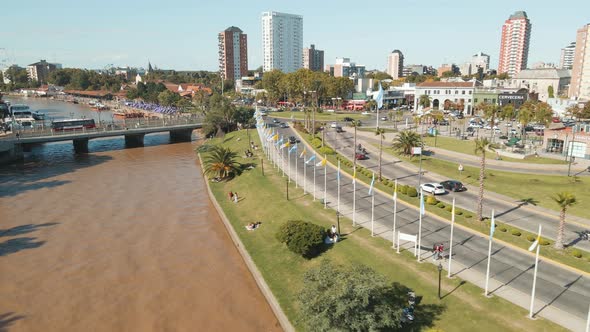 Aerial view of Tigre coastal walk near a bridge and facing the city at the end. Dolly in