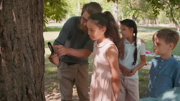 Teacher and Kids Inspecting Tree Bark with Magnifying Glass
