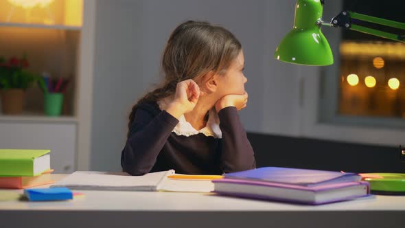 Very Tired Schoolgirl Sitting at Her Desk After School
