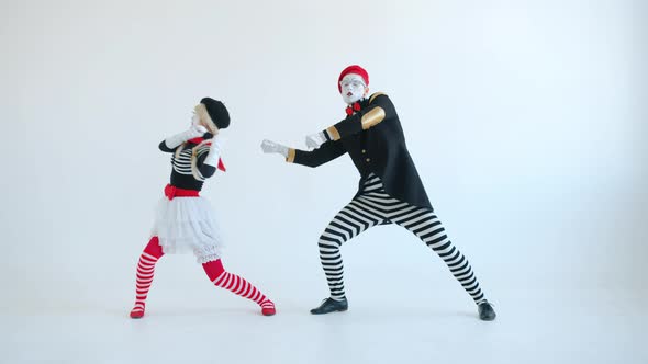 Mimes Girl and Guy Pulling Imaginary Rope Then Falling and Laughing on White Background