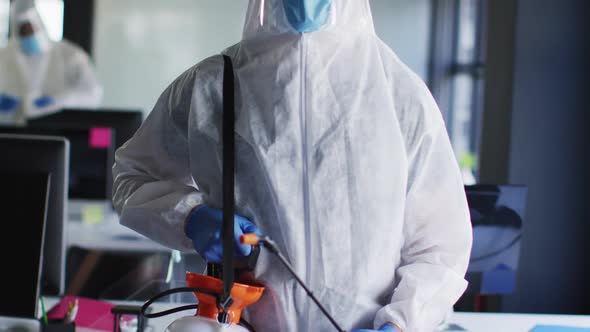 Portrait of health worker wearing protective clothes and face mask at modern office
