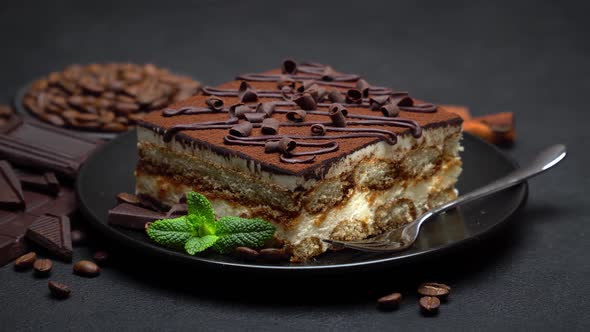 Portion of Traditional Italian Tiramisu dessert and pieces of chocolate bar