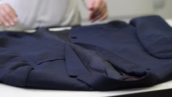 Hands of Dry-cleaning Worker Inspecting Jacket