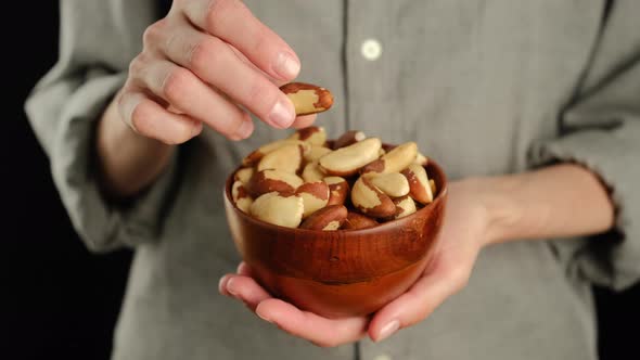 Female hold brazilian nuts in hand.