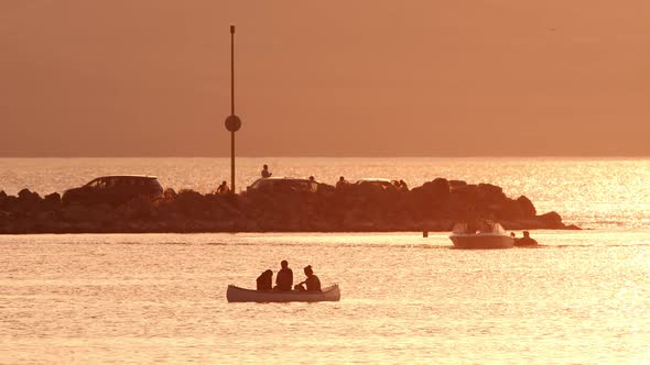 Canon with people floating on Utah Lake during sunset