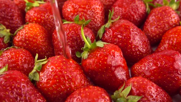 Splashes of water fall on strawberries.