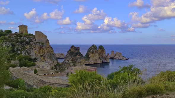 Clouds over stacks or Faraglioni of Scopello and Torre Doria tower in Sicily. Italy