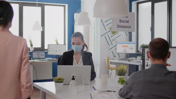 Coworkers Wearing Protective Face Mask Maintaining Social Distancing