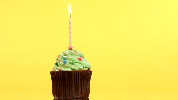 Tasty Birthday Cupcake with One Candle, on Yellow Background