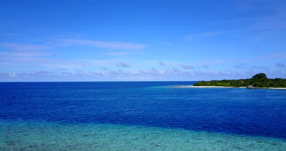 Wide overhead island view of a sunshine white sandy paradise beach and aqua blue ocean background in