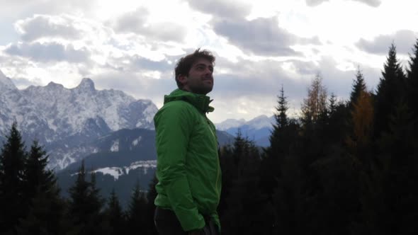 Portrait of a man looking at the snow and view of clouds and mountains in the winter