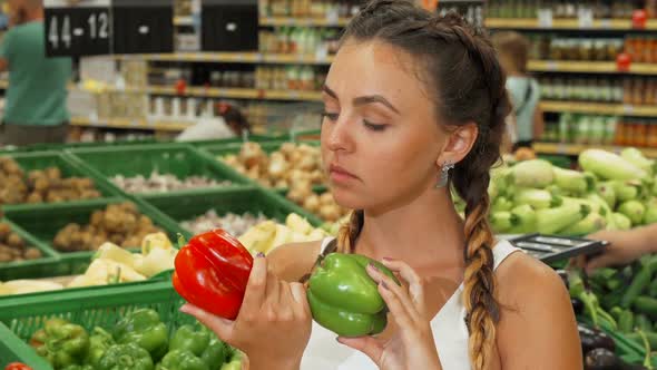 Young Woman Smelling Paprika at the Supermarket