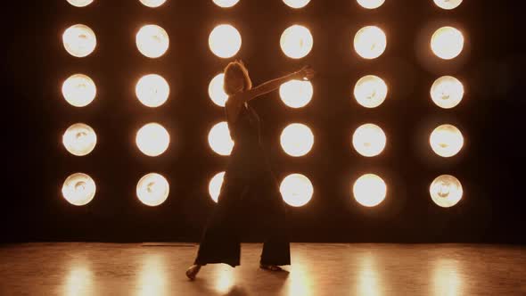 Beautiful woman dancing in front of a wall of lights