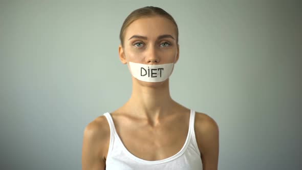 Thin Girl With Taped Mouth Holding Plate With Tomato, Exhausting Diet, Anorexia