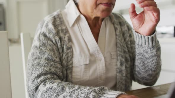 Stressed african american senior woman using laptop at home