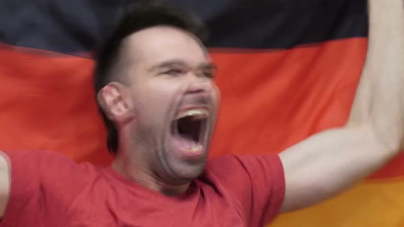 German Fan Celebrating While Holding the Flag of Germany