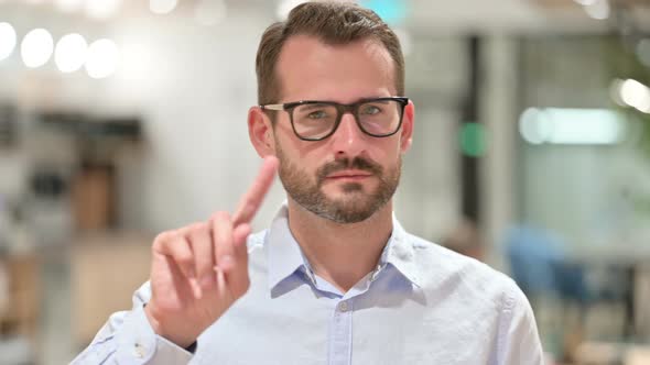 Portrait of Serious Businessman Saying No By Finger Sign