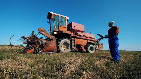 Combine Vehicle and an Agriscientist Walking Around It