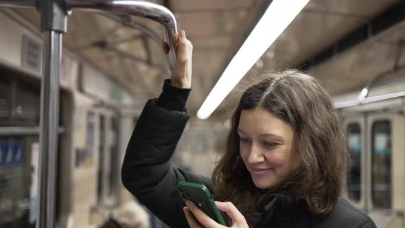 A Nice Woman with a Phone in Her Hands Goes to the Subway and Takes Hold of the Handrail