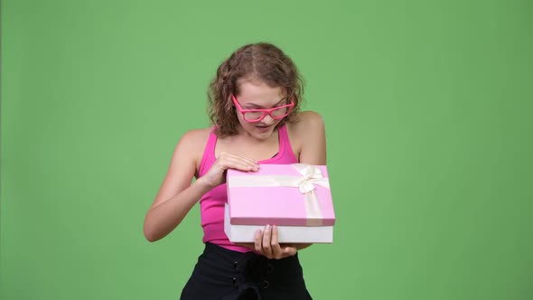 Young Happy Beautiful Nerd Woman Opening Gift Box and Looking Surprised