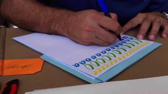 Man Practicing Calligraphy with Individual Letters 