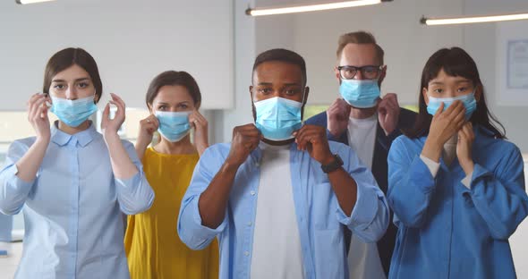 Multicultural Businesspeople Wearing Safety Mask Standing in Office