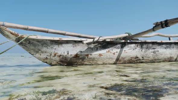 African Traditional Wooden Boat Stranded in Sand on Beach at Low Tide Zanzibar