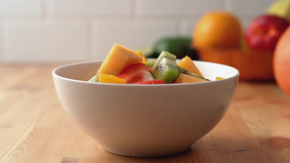 Camera follows a bowl of fruit salad. Slow Motion.